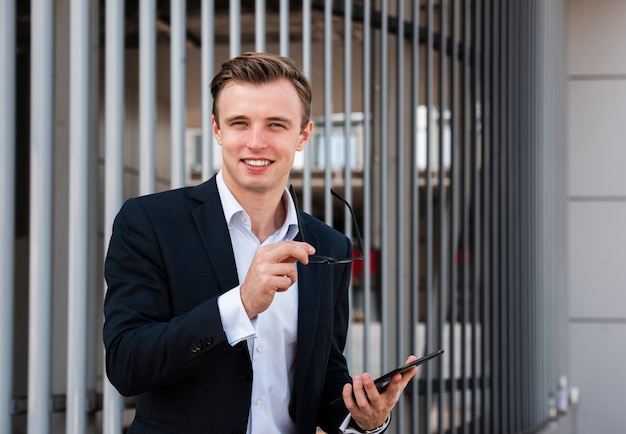 Foto gratuita empresario con tableta mirando a cámara