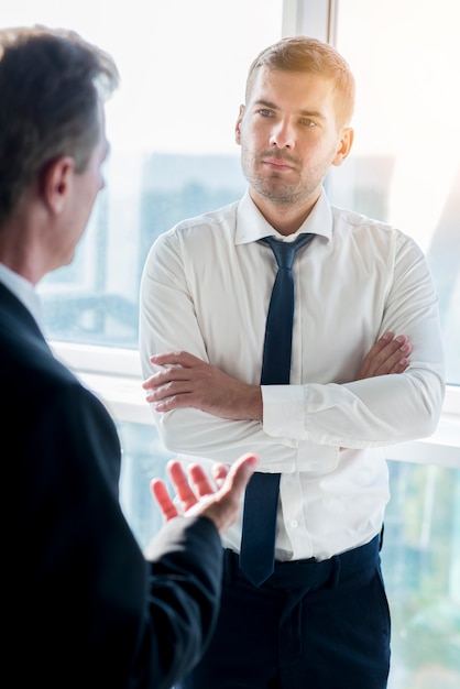 Foto gratuita empresario tener conversación con su compañero masculino en la oficina