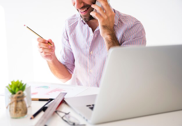 Empresario trabajando con el teléfono móvil y el ordenador portátil