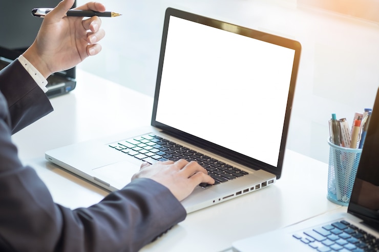 Foto gratuito empresario de trabajo portátil mientras está sentado en el escritorio, fondo borrosa, horizontal mockup