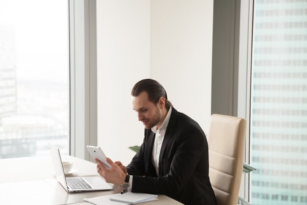 Empresario usando tableta mientras está sentado en el escritorio