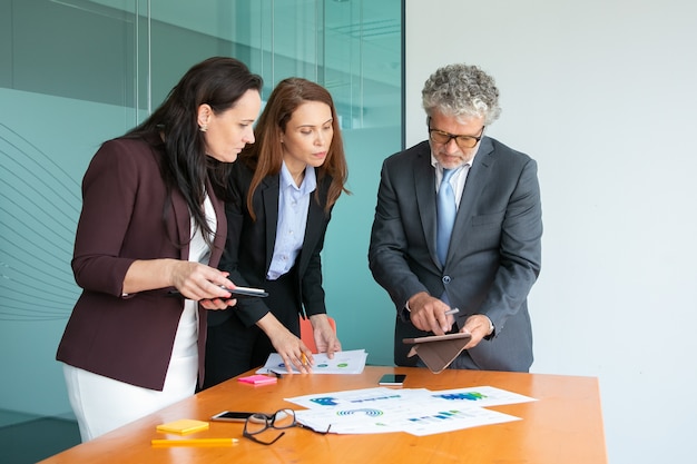 Empresarios de contenido viendo datos en la pantalla de la tableta