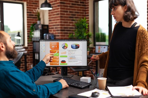 Los empresarios discutiendo la estrategia de gestión analizando los gráficos de datos de la empresa mediante una reunión de negocios de planificación informática en la oficina de inicio. Compañeros de trabajo intercambiando ideas de marketing