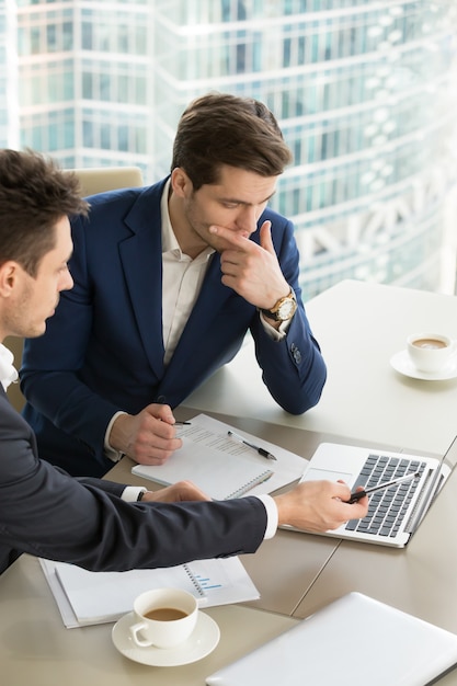 Empresarios discutiendo resultados de trabajo en reunión