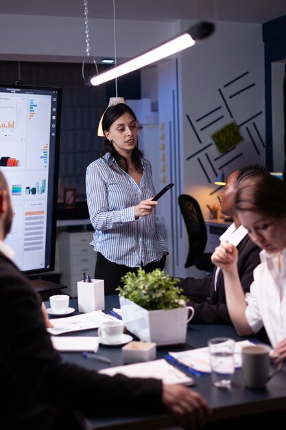 Empresarios diversos enfocados con exceso de trabajo que trabajan en la sala de reuniones de la empresa