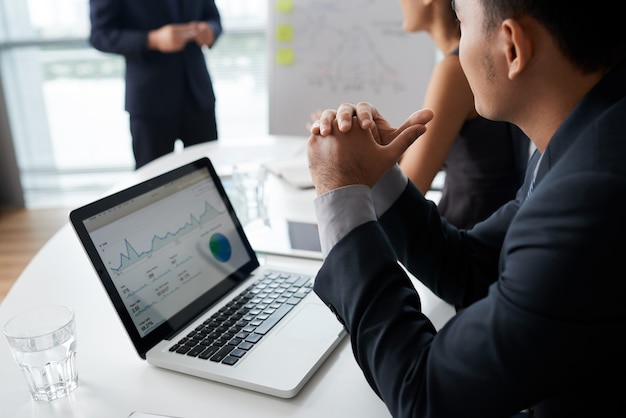 Empresarios escuchando a su colega en la reunión