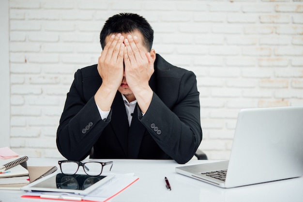 Foto gratuita empresarios infelices del hombre de negocios que se sientan en oficina