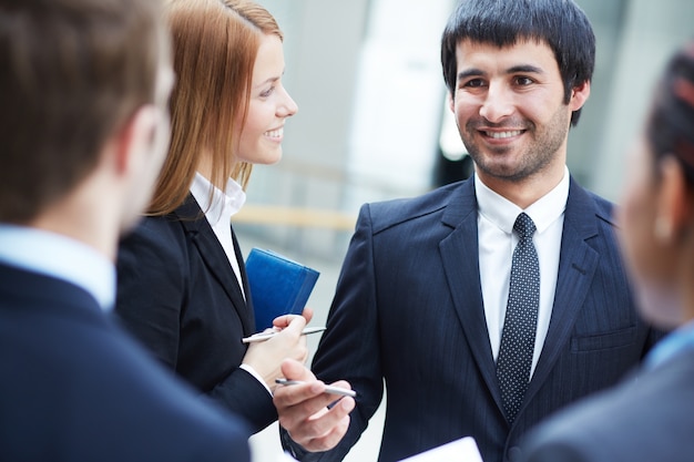 Empresarios jóvenes hablando juntos en la oficina