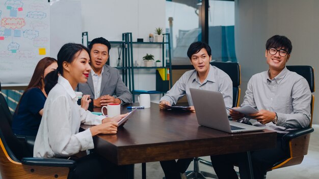 Los empresarios y mujeres de negocios del Milenio de Asia que tienen una videollamada en una conferencia y se reúnen ideas para intercambiar ideas sobre nuevos colegas del proyecto que trabajan juntos para planificar la estrategia disfrutan del trabajo en equipo en la oficina moderna