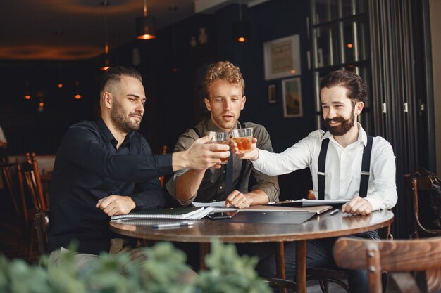 Empresarios en negociaciones. Hombres con alcohol sentados a la mesa. Los amigos están hablando.