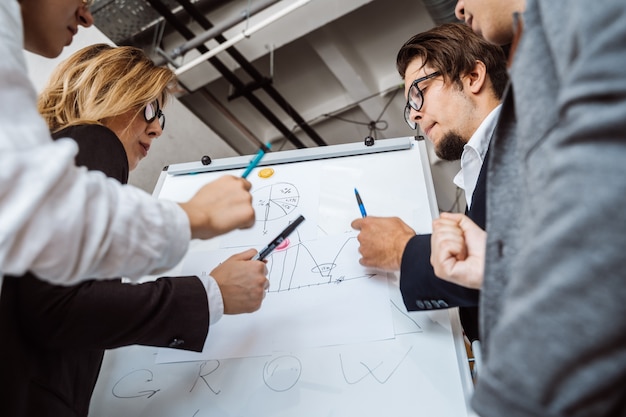 Empresarios con pizarra discutiendo estrategia en una reunión