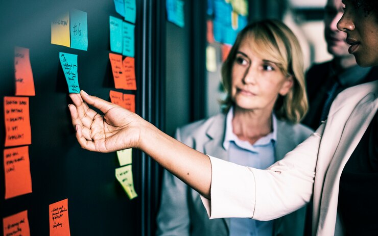 Foto gratuito empresarios planificación de tareas con notas adhesivas