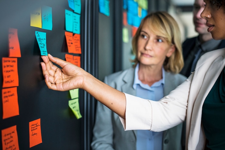 Foto gratuito empresarios planificación de tareas con notas adhesivas