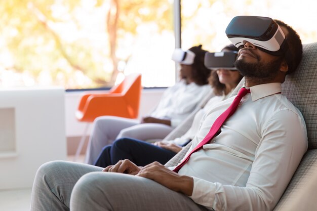 Empresarios serenos que disfrutan de la experiencia de realidad virtual