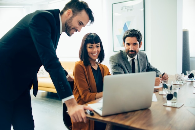 Empresarios sonrientes trabajando con el portátil