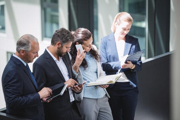 Empresarios mediante teléfono móvil y tableta digital