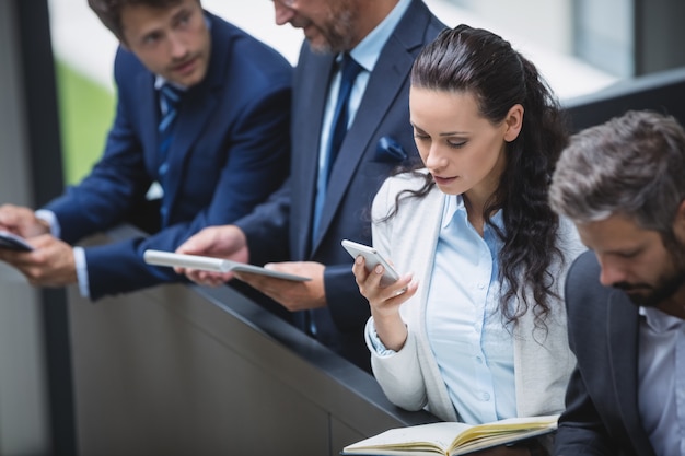 Empresarios mediante teléfono móvil y tableta digital