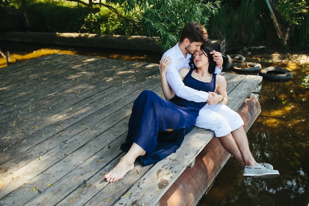 Enamorados relajados sentados en el lago