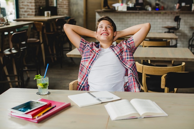 Foto gratuita encantado joven relajarse mientras estudia