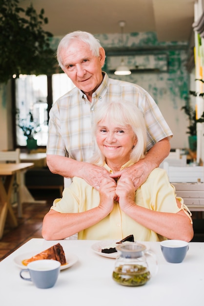 Encantado pareja de ancianos sentados en la cafetería