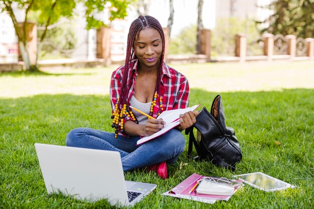 Encantador estudiante tomando notas mientras aprende