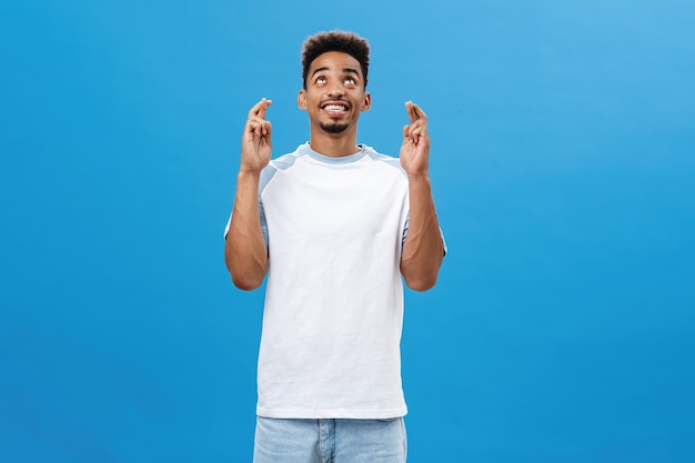 Encantador optimista hombre afroamericano pidiendo a dios que lo ayude esperando contento y feliz de piel oscura j ...