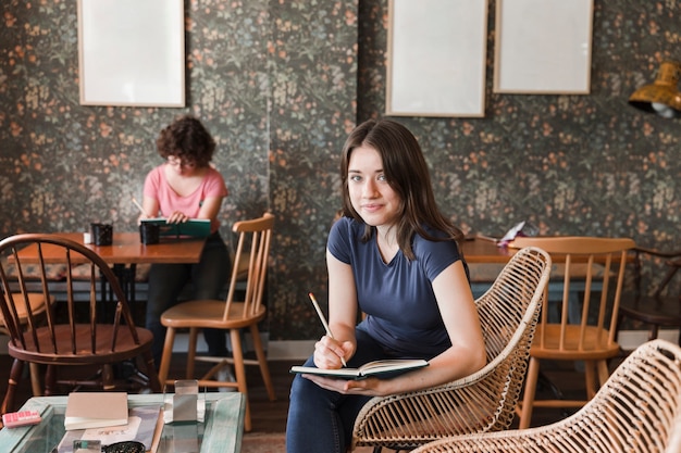 Encantadora chica adolescente con notebook en café