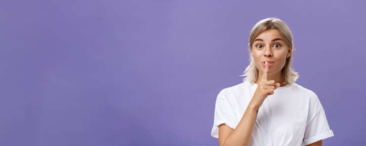 Foto gratuito encantadora chica bronceada creativa y elegante con el pelo rubio callándose a la cámara con deleite