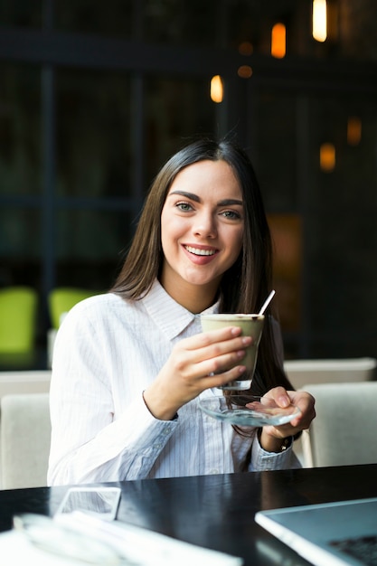 Encantadora chica tomando un café en el restaurante