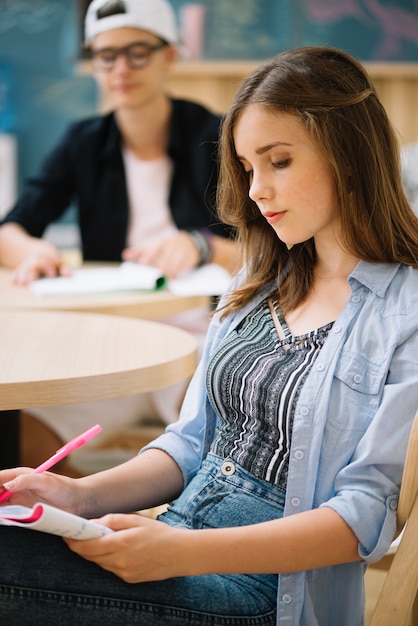 Foto gratuita encantadora colegiala concentrada en la lectura