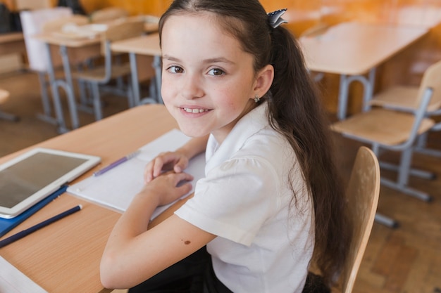 Encantadora colegiala mirando a la cámara