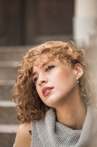 Encantadora dama con el pelo corto y rizado