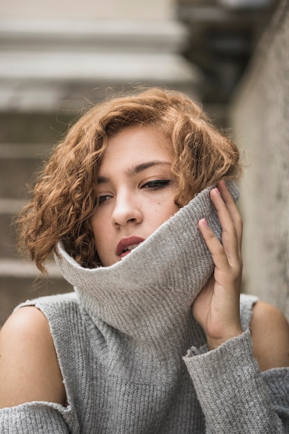 Foto gratuita encantadora dama con el pelo corto y tupido con el cuello del suéter levantado