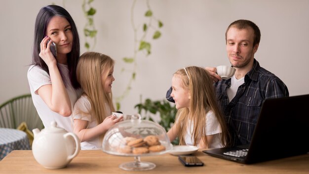 Encantadora familia en casa con laptop