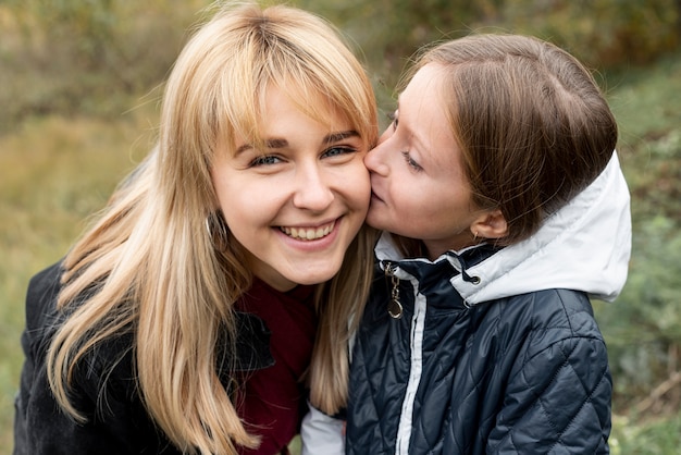 Encantadora hija besando a su madre