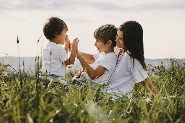 Encantadora joven madre se divierte con sus pequeños hijos