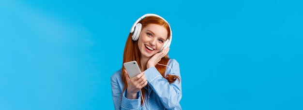 Foto gratuita encantadora joven soñadora fantaseando con escuchar canciones favoritas voz de cantante inclinar la cabeza y tocar