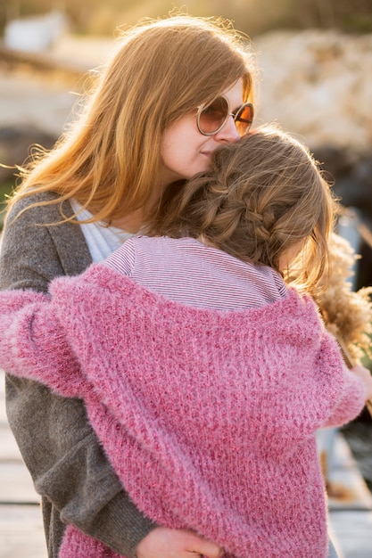 Foto gratuita encantadora madre abrazando niña de cerca