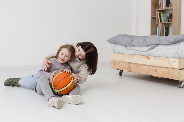 Encantadora mamá y niña disfrutando en el interior