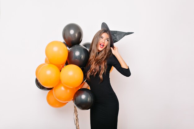 Encantadora mujer delgada posando con globos de colores