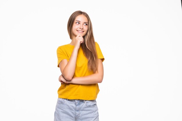 Encantadora mujer joven mirando a cámara aislada en la pared blanca