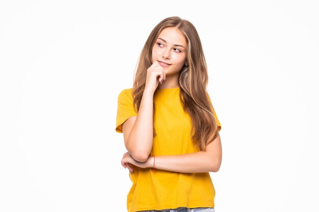 Encantadora mujer joven mirando a la cámara en la pared blanca