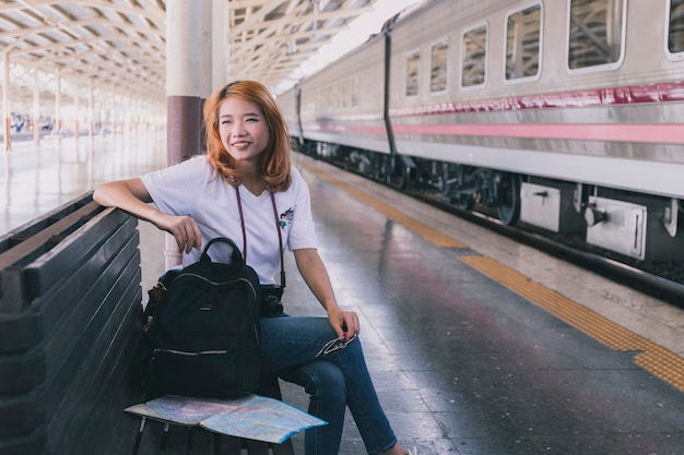 Encantadora mujer joven con mochila en la estación