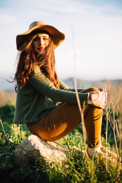 Encantadora mujer joven posando en piedra