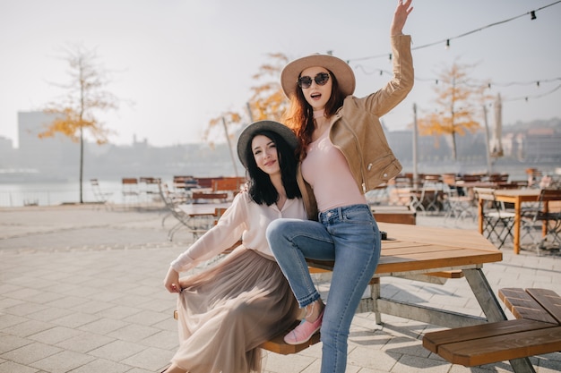 Encantadora mujer morena pasando el día de otoño con su mejor amigo