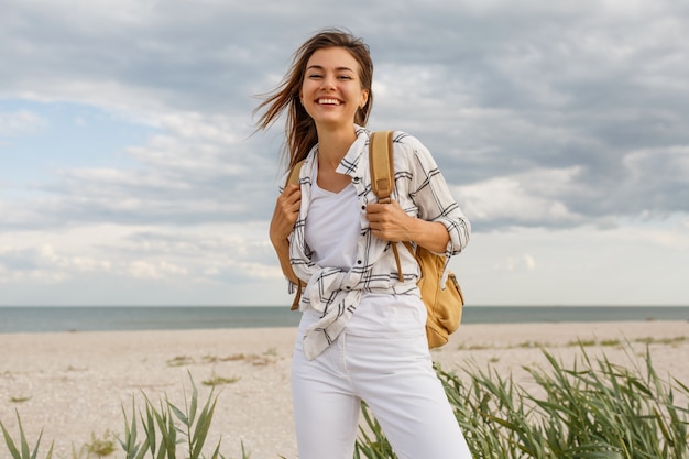 Encantadora mujer morena viajera elegante con mochila disfrutando de las vacaciones.