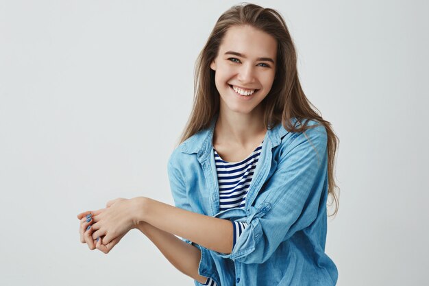 encantadora mujer tierna femenina que muestra felicidad actitud optimista positiva presionando las palmas juntas