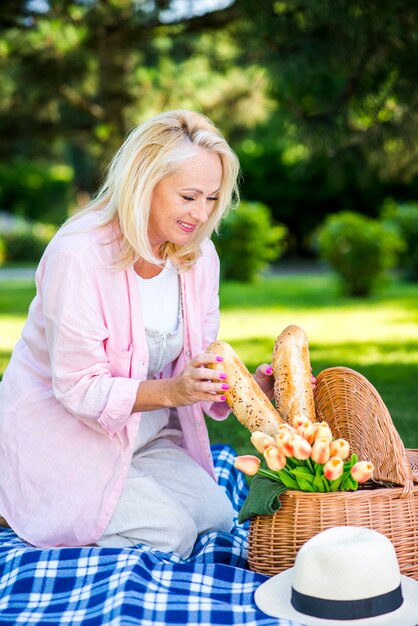 Encantadora mujer tomando pan de la cesta