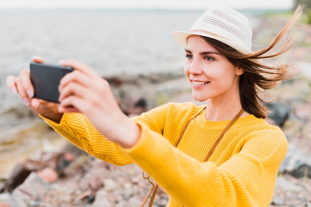 Encantadora mujer tomando un selfie en el mar