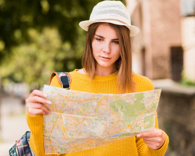 Encantadora mujer viajando leyendo el mapa